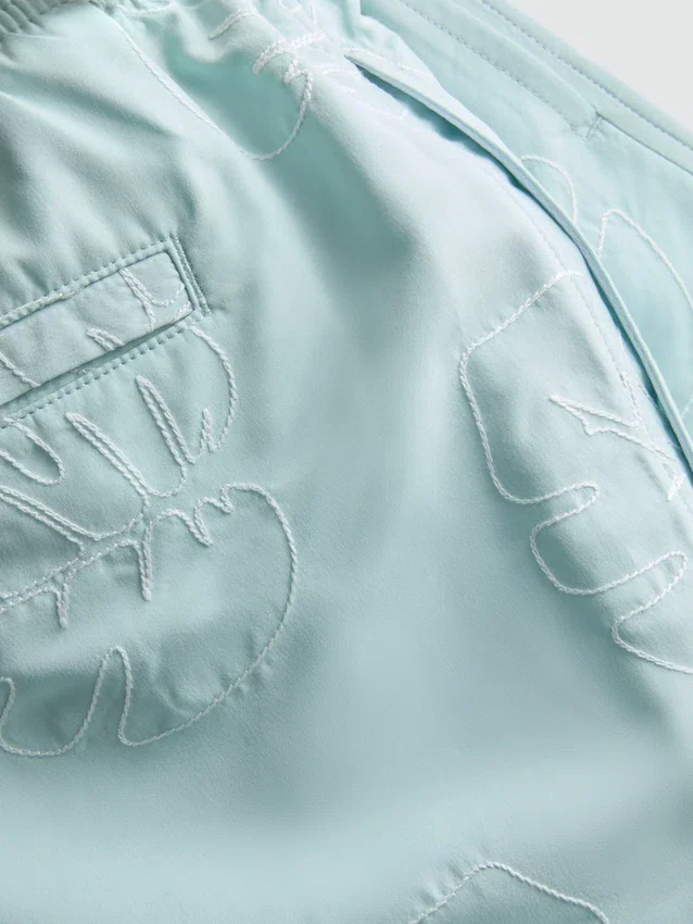 Badshorts med broderade löv