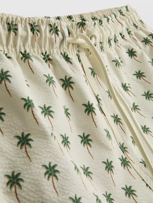 Badshorts med palmträdsmönster