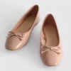Ballerinaskor i konstläder med rosett i lågskor