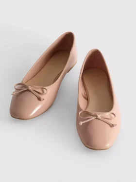 Ballerinaskor i konstläder med rosett i lågskor