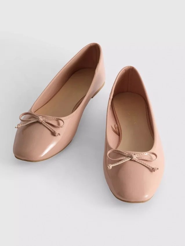 Ballerinaskor i konstläder med rosett i lågskor