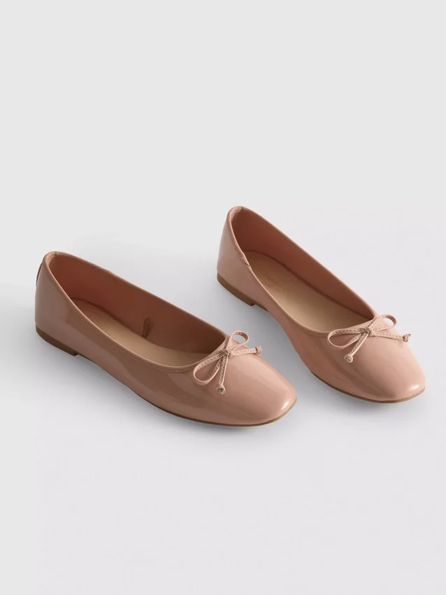 Ballerinaskor i konstläder med rosett i lågskor