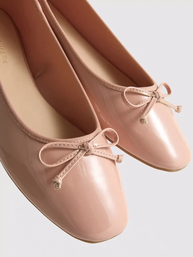 Ballerinaskor i konstläder med rosett i lågskor