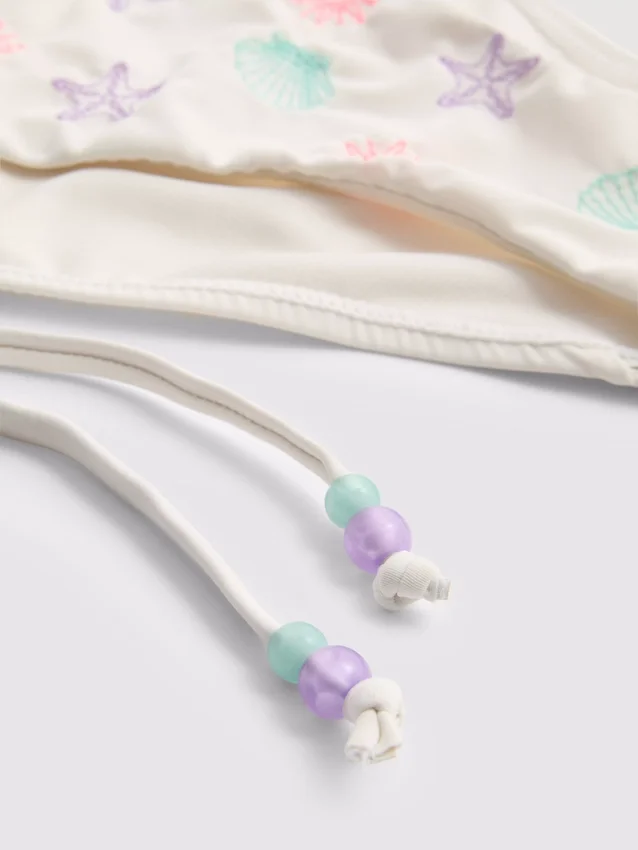 Bikinibottnar med broderat yttertyg och knytband i sidan