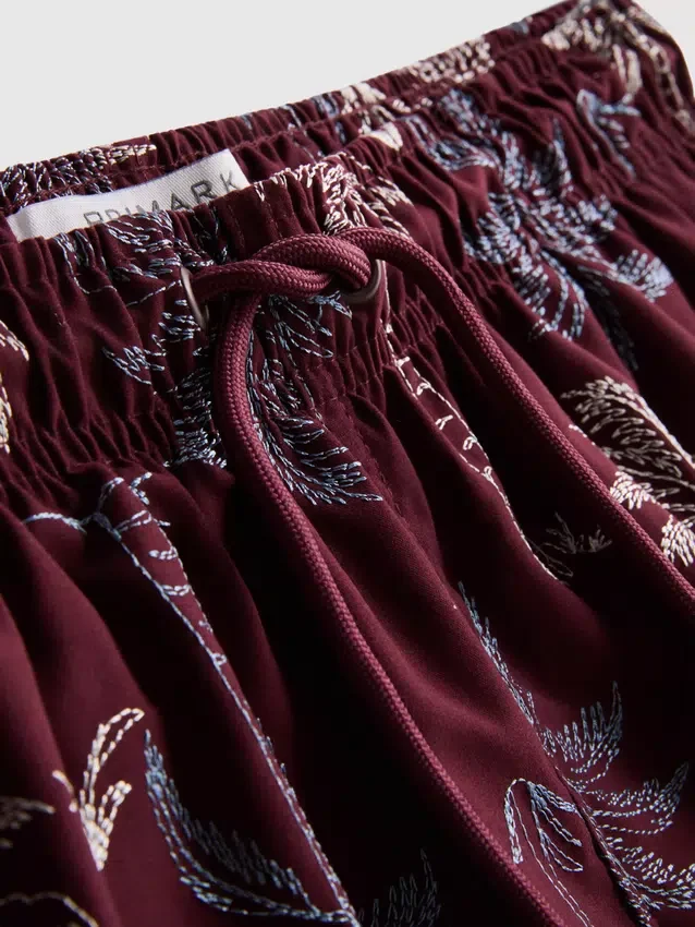 Broderade badshorts med palmträd