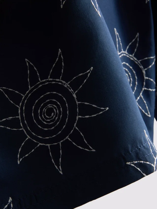 Broderade badshorts med solmotiv