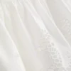 Cami-top i bomull med broderad peplum-kant
