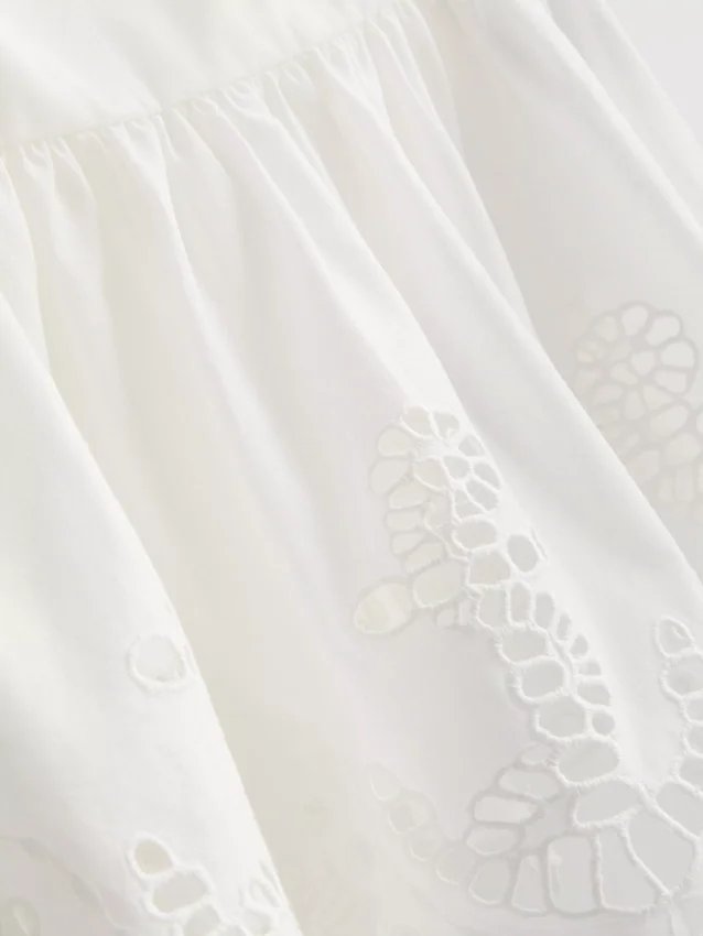 Cami-top i bomull med broderad peplum-kant