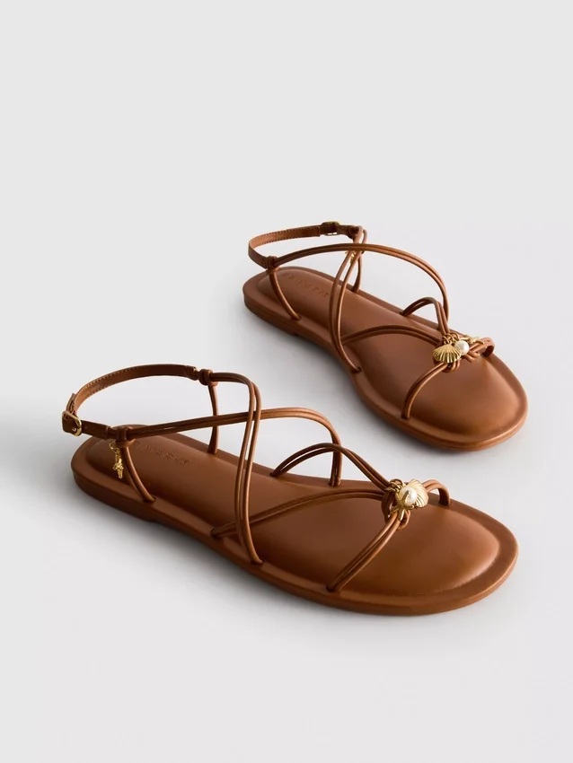 Paula Echevarría sandaler med remmar och charm
