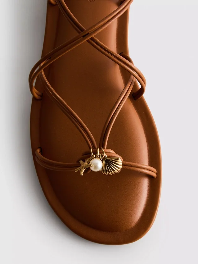 Paula Echevarría sandaler med remmar och charm